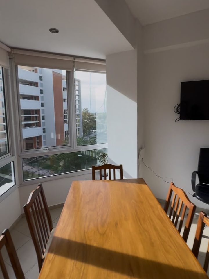Sala de reuniones con mesa de madera y ventanales